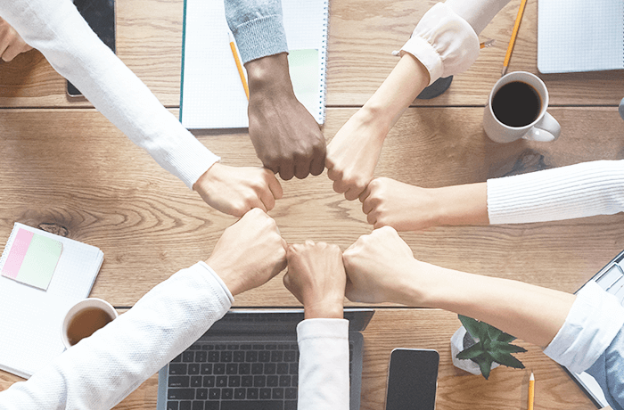 Varias personas uniendo sus puños en señal de equipo de trabajo. Varias personas uniendo sus puños en señal de equipo de trabajo.
