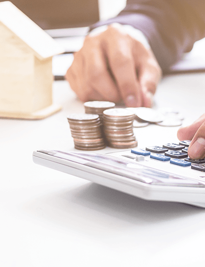 Una calculadora, al lado monedas y unas manos en la calculadora Una calculadora, al lado monedas y unas manos en la calculadora