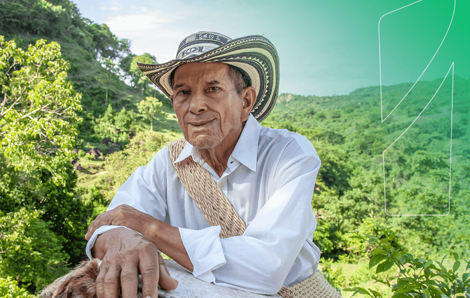 Hombre de edad con sombrero y mochila, vegetación de fondo