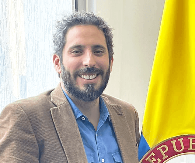 Presidente CISA Presidente de Central de Inversiones S.A junto a bandera de Colombia